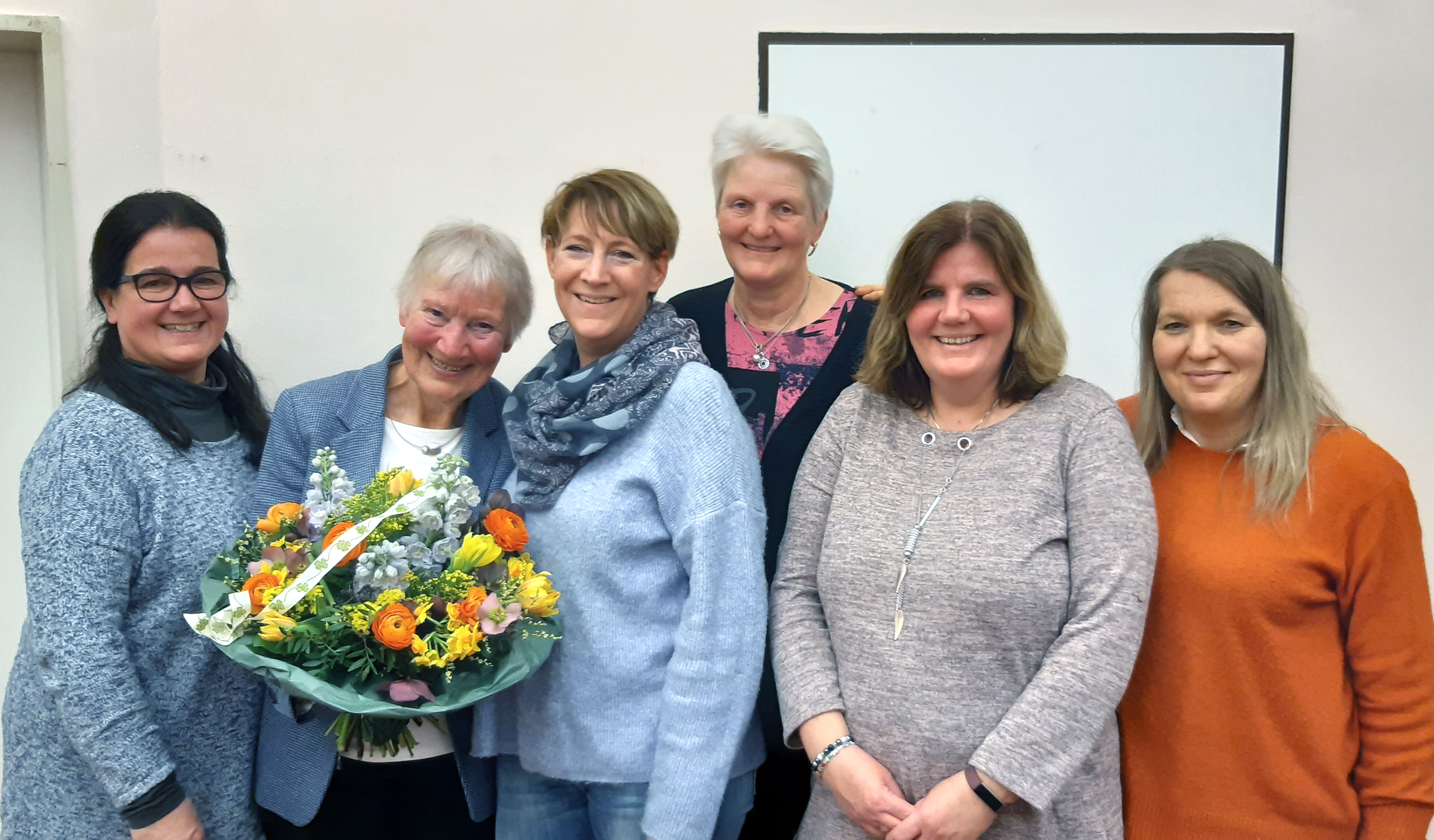 Mitglieder des DRK-Ortsvereins überreichen Bärbel Boller einen Blumenstrauß