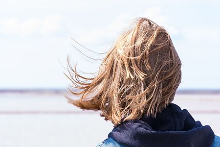 Frau schaut aufs Meer