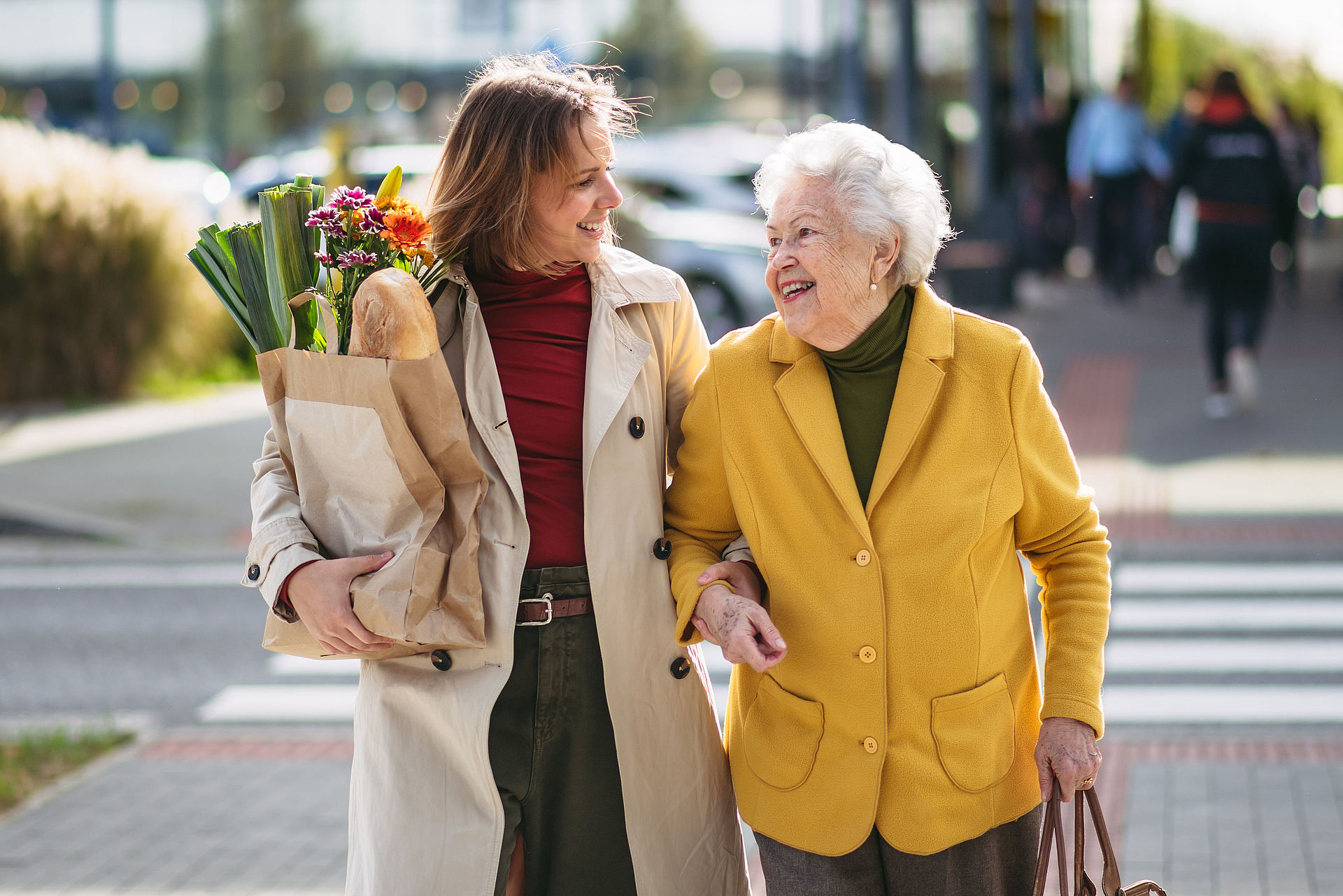 Seniorin geht zusammen mit der Seniorenassistenz zum Einkaufen