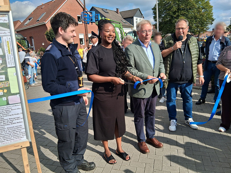 Kinderfest Gemeindevertreter Nick Köhler, Schleswig-Holsteins Ministerin für Soziales und Familie Aminata Touré und Appens Bürgermeister Hans-Peter Lütje stehen vor dem durchgeschnittenen Eröffnungsband