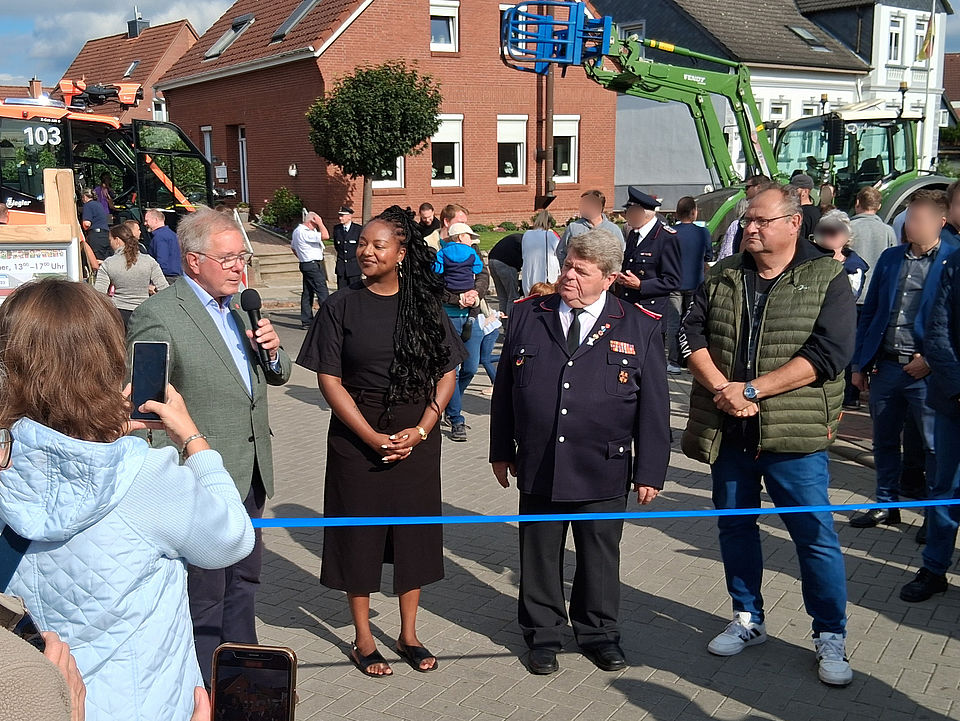 Kinderfest Appens Bürgermeister Hans-Peter Lütje stehe, Schleswig-Holsteins Ministerin für Soziales und Familie, Aminata Touré und Organisator Rolf Heidenberger stehen vor dem Eröffnungsband